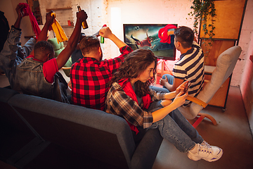 Image showing Group of friends watching TV, sport match together. Emotional fans cheering for favourite team, watching on exciting game. Concept of friendship, leisure activity, emotions