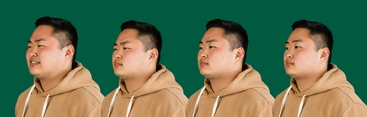 Image showing Evolution of emotions. Asian man\'s portrait isolated over green studio background with copyspace