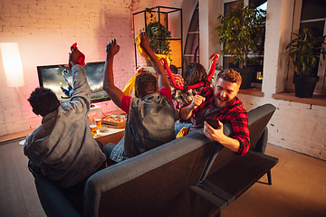 Image showing Group of friends watching TV, sport match together. Emotional man cheering for favourite team, celebrating successful betting. Concept of friendship, leisure activity, emotions