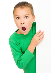 Image showing Little girl is looking out from the blank banner