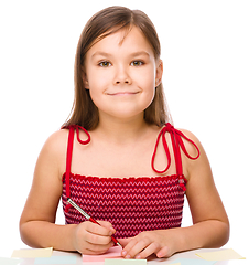 Image showing Girl is writing on color stickers using pen