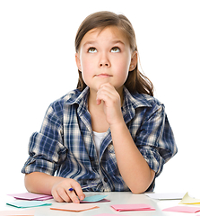 Image showing Girl is writing on color stickers using pen