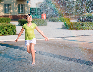 Image showing Girl is running through fountains