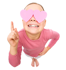 Image showing Little girl is holding hearts over her eyes