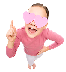 Image showing Little girl is holding hearts over her eyes