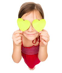 Image showing Little girl is holding hearts over her eyes