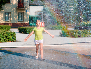 Image showing Girl is running through fountains
