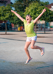 Image showing Girl is running through fountains