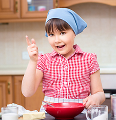 Image showing Girl is cooking in kitchen