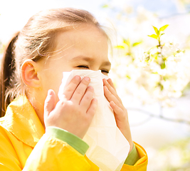 Image showing Little girl is blowing her nose