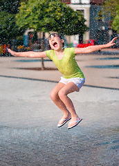 Image showing Girl is running through fountains