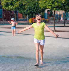 Image showing Girl is running through fountains