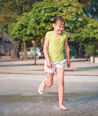 Image showing Girl is running through fountains