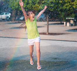 Image showing Girl is running through fountains