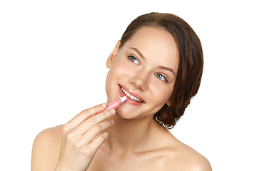 Image showing girl applying lipgloss