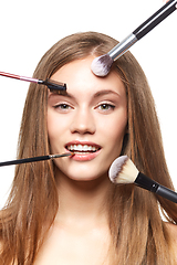 Image showing beautiful girl with makeup brushes