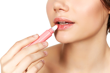 Image showing girl applying lipgloss