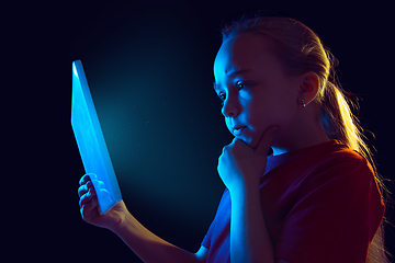 Image showing Caucasian girl\'s portrait isolated on dark studio background in neon light