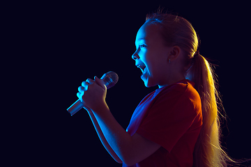 Image showing Caucasian girl\'s portrait isolated on dark studio background in neon light