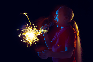 Image showing Caucasian girl\'s portrait isolated on dark studio background in neon light