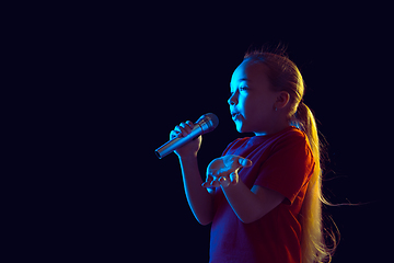 Image showing Caucasian girl\'s portrait isolated on dark studio background in neon light