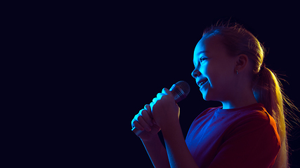 Image showing Caucasian girl\'s portrait isolated on dark studio background in neon light