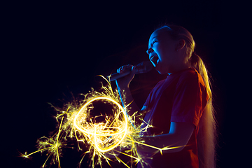 Image showing Caucasian girl\'s portrait isolated on dark studio background in neon light