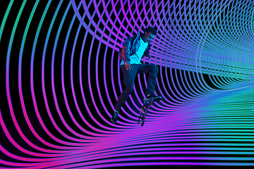 Image showing Caucasian young skateboarder riding on dark neon lighted line background