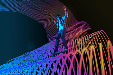 Image showing Caucasian young skateboarder riding on dark neon lighted line background