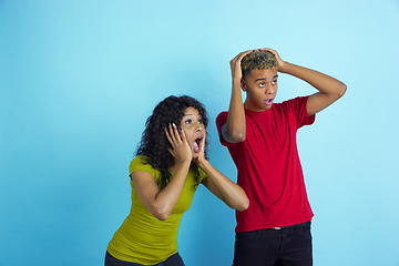 Image showing Young emotional african-american man and woman on blue background