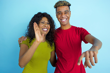 Image showing Young emotional african-american man and woman on blue background