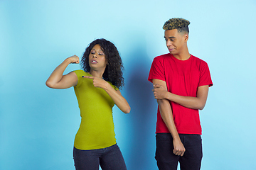 Image showing Young emotional african-american man and woman on blue background