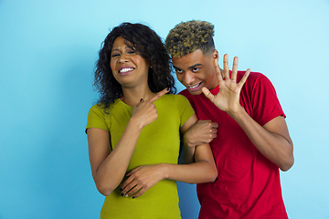 Image showing Young emotional african-american man and woman on blue background