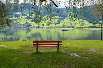 Image showing A calm place to rest and relax. An empty wooden bench. Switzerland