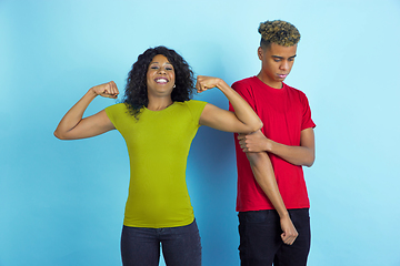 Image showing Young emotional african-american man and woman on blue background