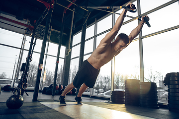 Image showing The male athlete training hard in the gym. Fitness and healthy life concept.