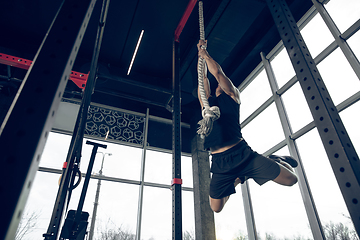 Image showing The male athlete training hard in the gym. Fitness and healthy life concept.