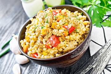 Image showing Barley porridge with minced meat in bowl on wooden board