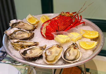 Image showing Large dish with fresh seafood, oysters with lobster with lemon a