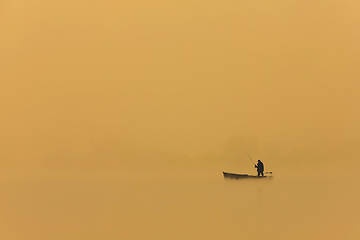 Image showing man fishing from boat at sunset