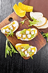 Image showing Bruschetta with pumpkin and arugula on black board top