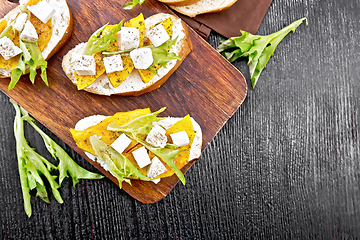 Image showing Bruschetta with pumpkin and arugula on board top