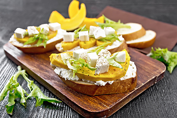 Image showing Bruschetta with pumpkin and arugula on board