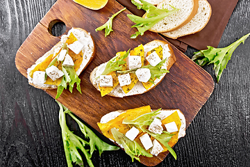 Image showing Bruschetta with pumpkin and arugula on wooden board top