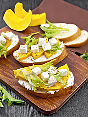 Image showing Bruschetta with pumpkin and arugula on wooden board