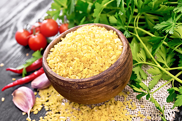 Image showing Bulgur in bowl with vegetables on black wooden board