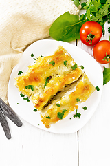 Image showing Cannelloni with curd and spinach in plate on board top