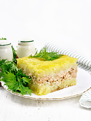 Image showing Casserole with potatoes and fish in plate on light table