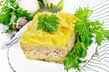 Image showing Casserole with potatoes and fish in plate on white wooden board