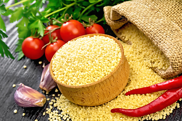 Image showing Couscous raw in bowl on dark wooden board